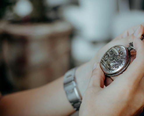 A close-up image of a person holding a vintage pocket watch, possibly symbolizing inheritance or sentimental items passed down after a deceased person’s estate is settled—relevant in the context of an insolvent estate where not all assets may be distributed to family members